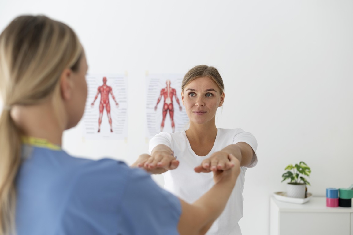 Physiotherapist helping female patient her clinic
