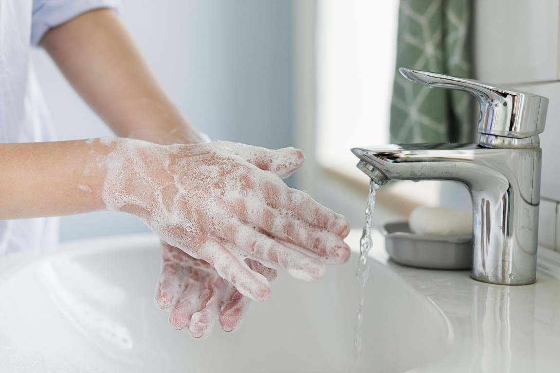 Side view person washing hands sink